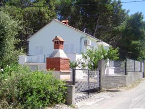 Biały dom z ceglanym kominem i płotem w obiekcie Holiday home w mieście Sušica