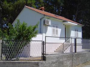 mały biały dom z płotem przed nim w obiekcie Holiday home w mieście Sušica