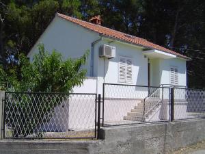 ein kleines weißes Haus mit einem Zaun davor in der Unterkunft Holiday home in Sušica