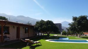 La Victoria de AcentejoにあるVillas Norte Piscina privada climatizadaの庭(プール付)と山を背景にした家
