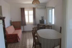 ein Wohnzimmer mit einem Tisch und einem TV in der Unterkunft Holiday home in Sušica