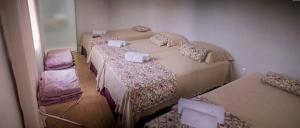 pokój z 3 łóżkami i 2 krzesłami w obiekcie Hotel Gabriel w mieście Santa Maria