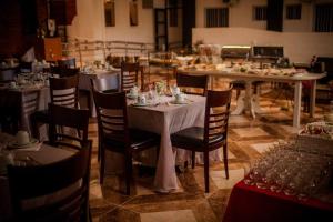 a dining room with tables and chairs with food on them at Hotel Gabriel in Santa Maria