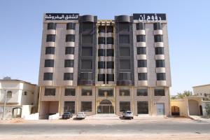 a building with cars parked in front of it at Raoum Inn Hail in Hail