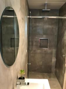 a bathroom with a shower with a sink and a mirror at CBD Apartments Launceston in Launceston