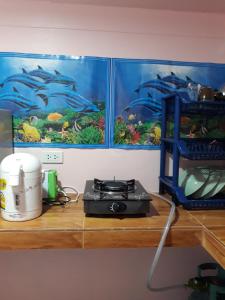a counter with a stove on a shelf with paintings at Easy Life Bungalows in Haad Yao +56 photos