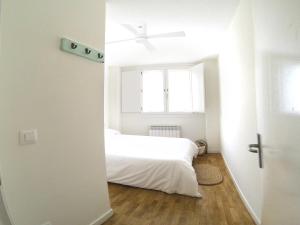 1 dormitorio con cama blanca y ventana en Luxury Cuchillería Vitoria, en Vitoria-Gasteiz