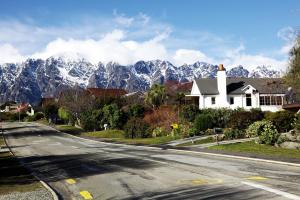 an empty road in front of a mountain at Sunny Lakeside Haven in Queenstown