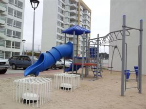 a playground with a blue slide in the sand at Departamento en Condominio Costamar La Herradura in Coquimbo