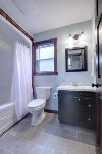 a bathroom with a toilet and a sink and a mirror at Bambury's Hillside Chalets in Rocky Harbour