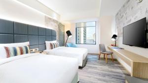una camera d'albergo con due letti e una TV a schermo piatto di HOTEL CHAM CHAM - Taipei a Taipei