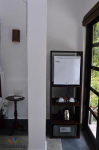 a living room with a television and a table at Wasantha Garden Hotel Restaurant & Ayurvedic Treatment in Weligama