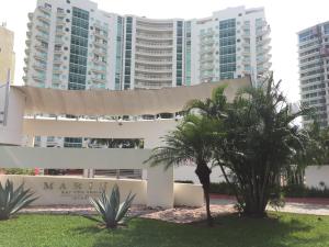 un edificio con palmeras frente a edificios altos en Bay View Grand Marina 203 - Sur, en Ixtapa