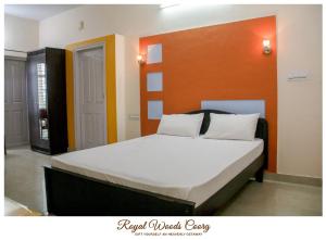 a bedroom with a large bed with an orange headboard at Royal Woods Coorg in Madikeri
