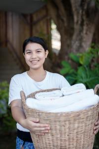 a young boy holding a basket of towels at Sarikantang Resort & Spa, Koh Phangan in Haad Rin