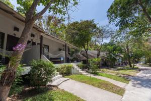 a house with trees and a sidewalk in front of it at Sarikantang Resort & Spa, Koh Phangan in Haad Rin