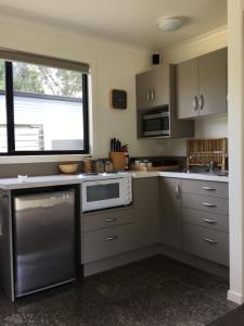 een keuken met een wastafel en een magnetron bij Nextdoor@portarthur in Port Arthur
