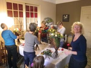 un grupo de personas de pie alrededor de una mesa con flores en La Grange en Champagne, en Hermonville