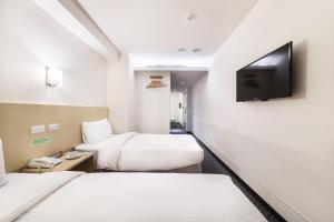 Habitación de hotel con 2 camas y TV de pantalla plana. en Green World Linsen en Taipéi