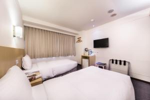 台北市にあるグリーンワールド 林森のベッド2台とテレビが備わるホテルルームです。