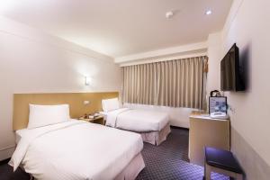 台北市にあるグリーンワールド 林森のベッド2台、薄型テレビが備わるホテルルームです。