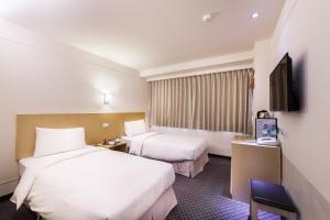 a hotel room with two beds and a flat screen tv at Green World Linsen in Taipei