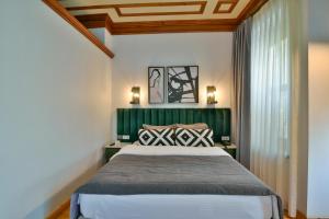 a bedroom with a large bed with a green headboard at Istanbul Life Hotel in Istanbul