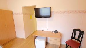 a room with a desk with a television on the wall at Armenia in Garliava