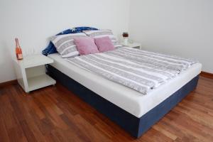 uma cama com almofadas cor-de-rosa num quarto em Apartman Bellevue em Spindleruv Mlyn