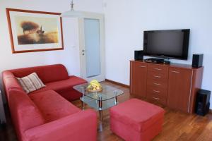 uma sala de estar com um sofá vermelho e uma televisão em Apartman Bellevue em Spindleruv Mlyn