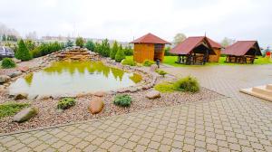 a pond in a yard with a pavilion and a house at Armenia in Garliava