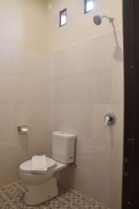 a bathroom with a toilet and a shower at Hotel Orizatha in Mataram