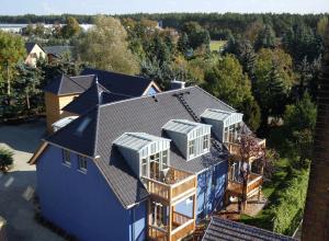 une vue aérienne sur une maison avec un toit dans l'établissement BluGarden Ferienapartments im Spreewald, à Lübben