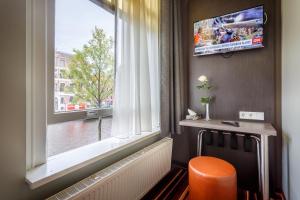 a room with a large window with a radiator and a chair at Mozart Hotel in Amsterdam