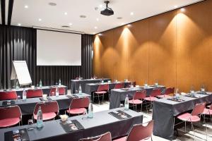 una sala conferenze con tavoli, sedie e schermo di Best Western Plus Hotel Alfa Aeropuerto a Barcellona