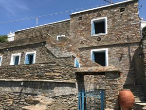 a stone building with a blue door at Petra Traditional House in Episkopión
