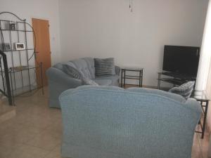 sala de estar con sofá y TV en Villa in Universal en Pafos