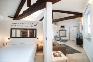 una camera da letto con un letto bianco e un soggiorno di ReArduinoIvrea a Ivrea
