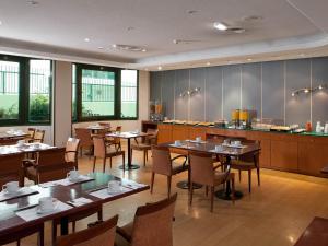 a restaurant with tables and chairs and a counter at Apartamentos TH Las Rozas in Las Rozas de Madrid