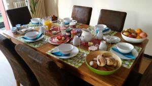 una mesa de madera con productos para el desayuno en Quillan La Vue - Chambres d'hôtes, en Quillan
