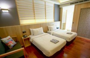 a hotel room with two beds and a window at Tangyue Resort in Tai'an