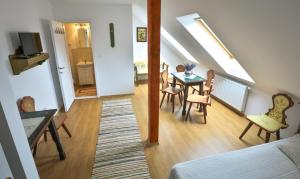 sala de estar con mesa y sillas y escalera en Casa Júlia, en Odorheiu Secuiesc