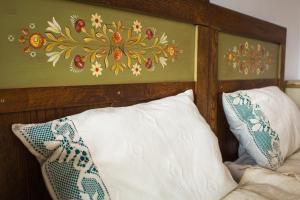 ein Bett mit zwei Kissen und einem Gemälde an der Wand in der Unterkunft Casa Júlia in Odorheiu Secuiesc