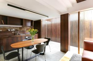uma cozinha e sala de jantar com uma mesa de madeira e cadeiras em Stone Flower em Hobart