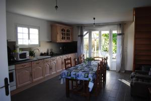 Liesville-sur-DouveにあるGite Les Marais de la Douveのキッチン(テーブル、椅子付)、窓付きのキッチン