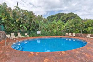 una grande piscina con sedie e alberi sullo sfondo di Kaanapali Plantation Condominiums a Kaanapali