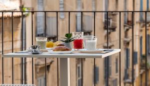 Duomo Suites & Spa في كاتانيا: طاولة مع أطباق من الطعام والمشروبات على شرفة