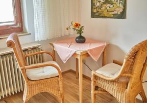 a table with a vase on it with two chairs at Appartement Petit in Saalbach-Hinterglemm