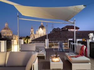 balcón con muebles blancos y vistas a la ciudad en Duomo Suites & Spa, en Catania