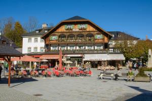 a large building with tables and chairs in front of it at Hotel Schiffmeister in Schönau am Königssee